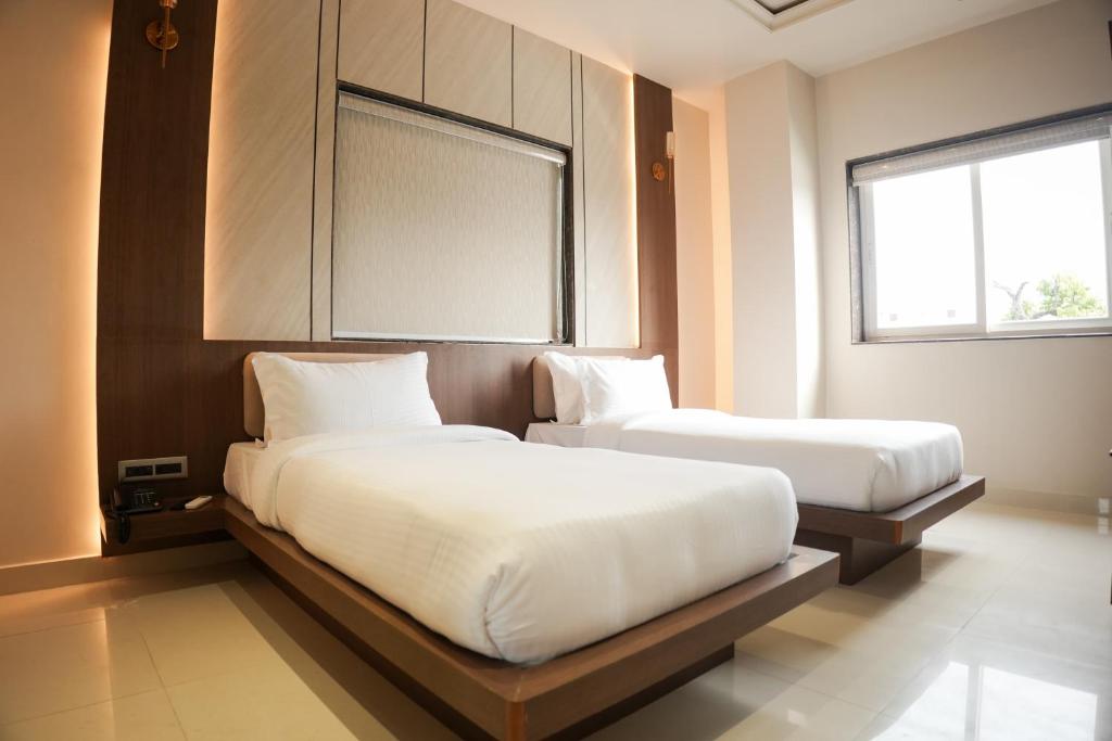 a bedroom with two beds and a window at DHANUSH STAYS - A Boutique Accommodation in Varanasi