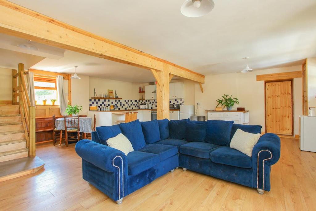 a large blue couch in a living room at Dulcie's Cottage in Wootton