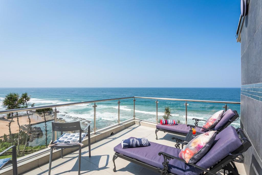 a balcony with two lounge chairs and the ocean at Sea View Luxury Penthouse in Ballito