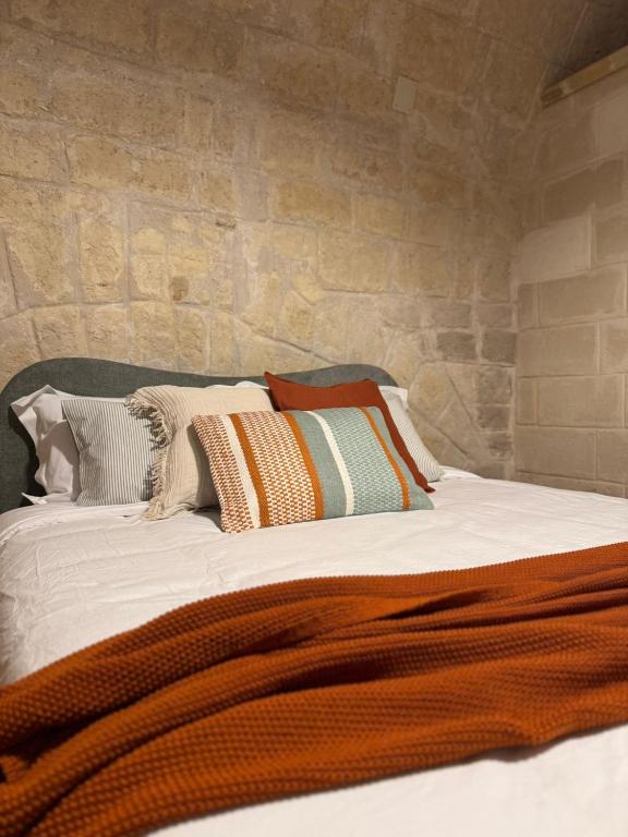 a bed with many pillows on top of it at Dimora Antica Santa Chiara in Trani