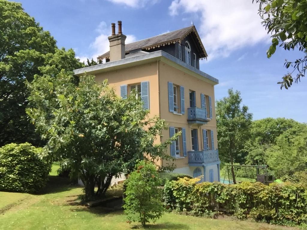 an old house with a tree in front of it at La maison de Blandine in Honfleur