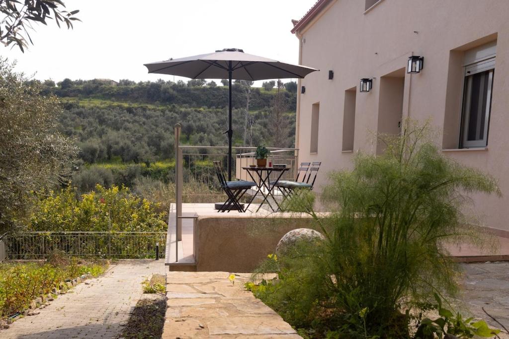 a patio with an umbrella next to a building at Sarantou House in Koroni