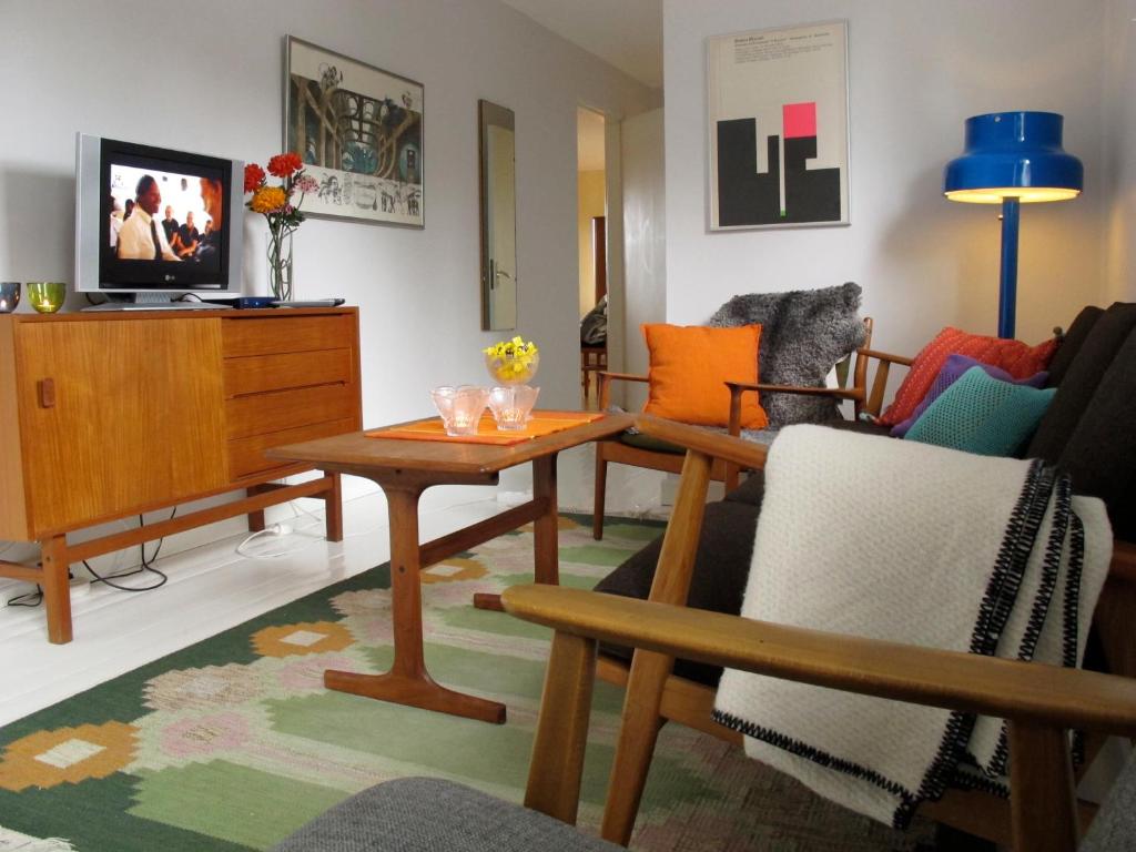 a living room with chairs and a table and a tv at Bo på Lanthandel in Norråker