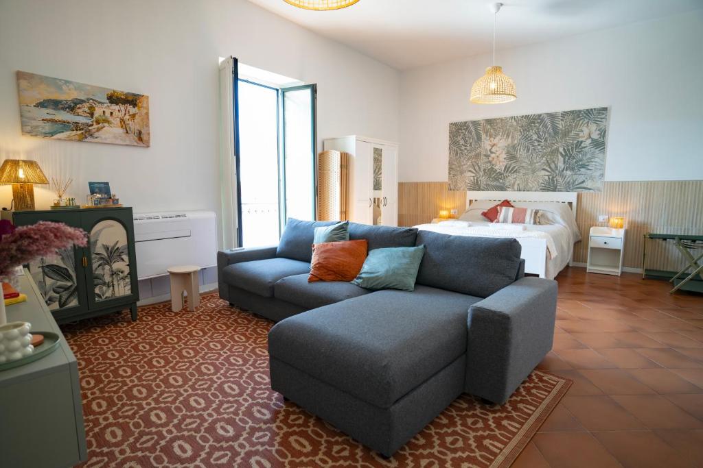a living room with a couch and a bed at Open Space Suite in the Center of Salerno, modern apartment into Historic District, 250 meters from seafront and 20 meters from the Main Street Corso Garibaldi in Salerno