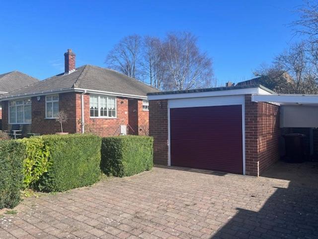 a brick house with a garage in front of it at Westfields Bungalow in Mirfield