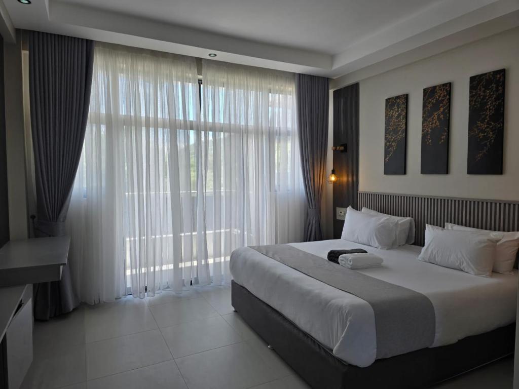 a bedroom with a large bed and a large window at Oloisiri Namanga Hotel in Namanga