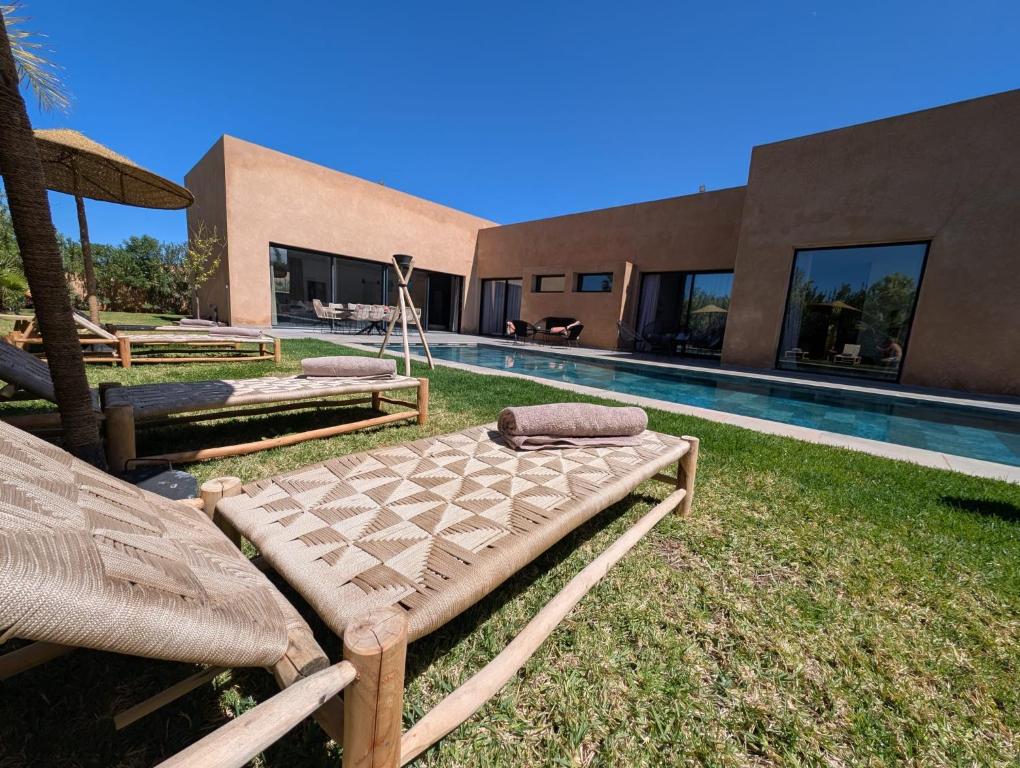 a backyard with two beds and a swimming pool at Villa LaLa in Marrakesh