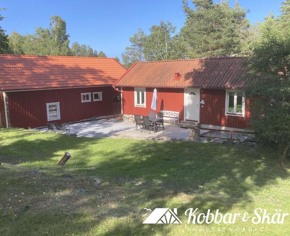 a couple of red buildings with a yard at Two cozy accommodations near the sea SE09118 in Gåseknöde