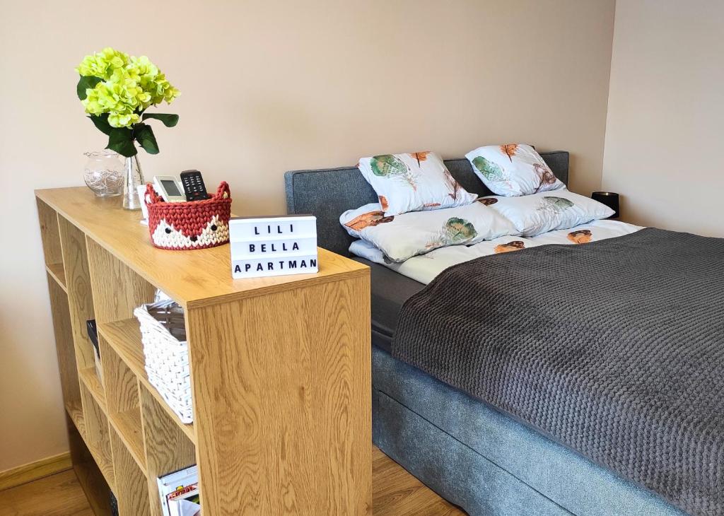 a room with a bed and a table with a couch at Lilibella apartman in Miskolc