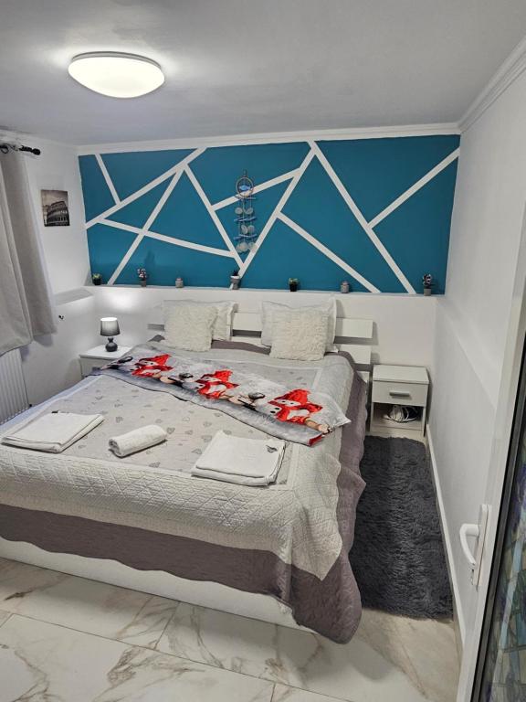 a bedroom with a large bed with a blue wall at Studio Superior Iris in Baile Felix