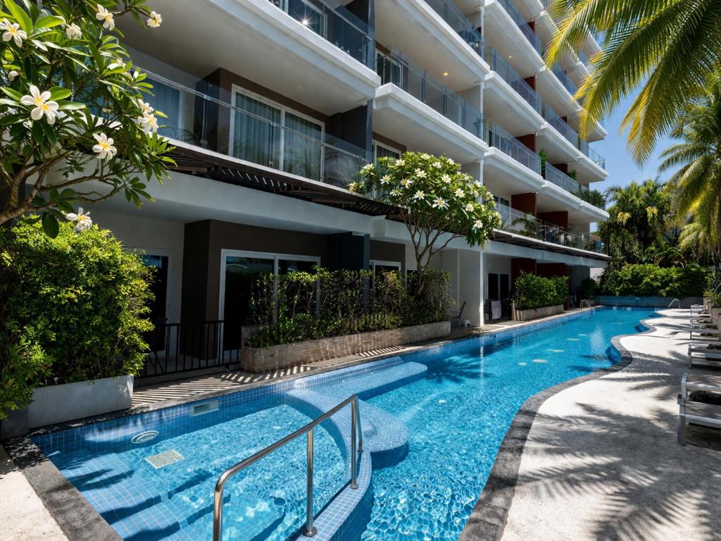 a swimming pool in front of a building at Condo Vireo Pool View Rawai in Phuket