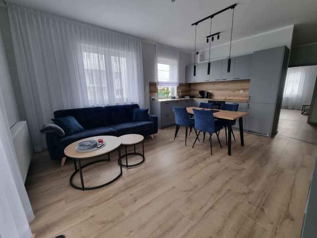 a living room with a blue couch and a table at Apartament Marzeń 13 parter in Kostrzyn nad Odrą
