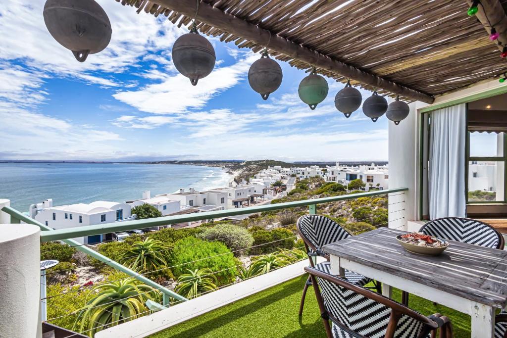 a balcony with a table and chairs and a view of the ocean at 43 Artemis, Langebaan, 8-sleeper in Langebaan