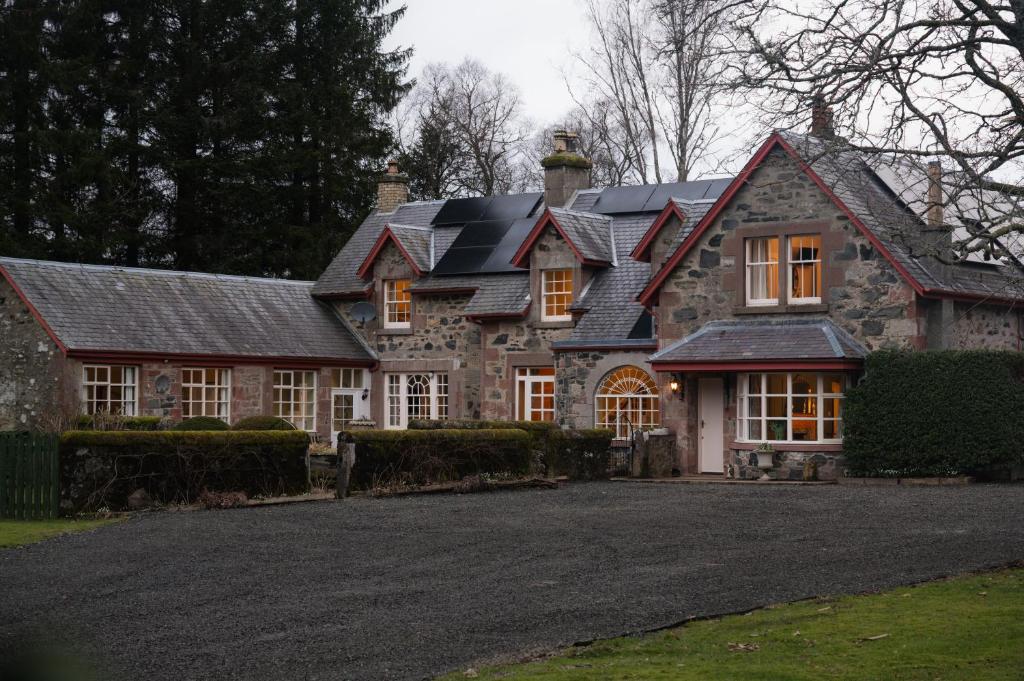 a large stone house with a black roof at Bleaton Hallet House Riverside Escape in Kingseat