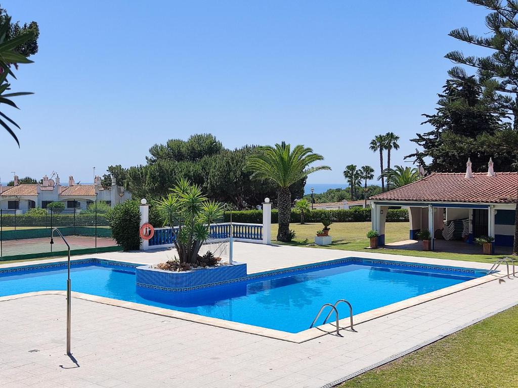a swimming pool in a yard next to a house at 06 Sra da Rocha - Casas & Papeis in Porches