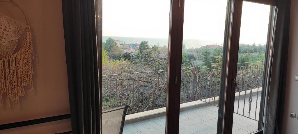 a room with a view of a balcony at Stone house with seaview in Nea Potidaea