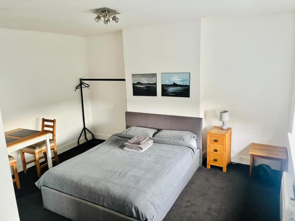a bedroom with a bed and a table and a desk at 26 Station Way in Cheam