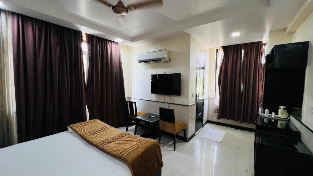 a hotel room with a bed and a television at Aadhar Hotel in Gurgaon
