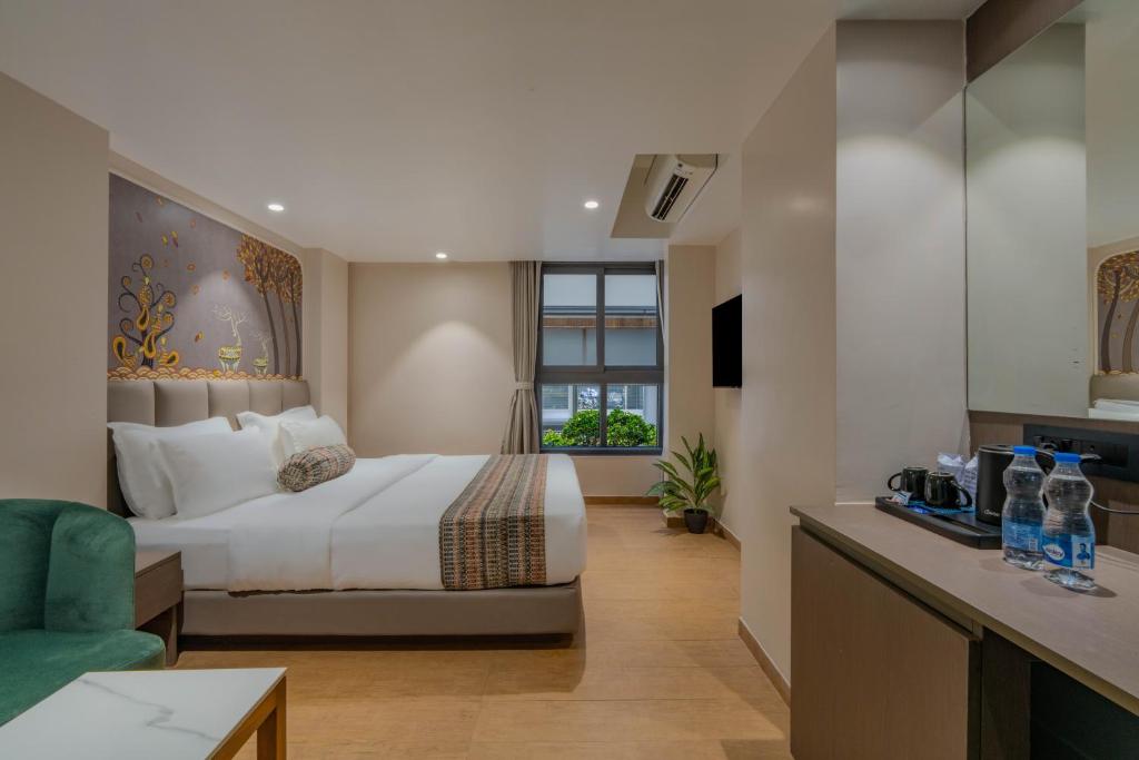 a hotel room with a bed and a couch at Hotel Shivashish in Ahmedabad