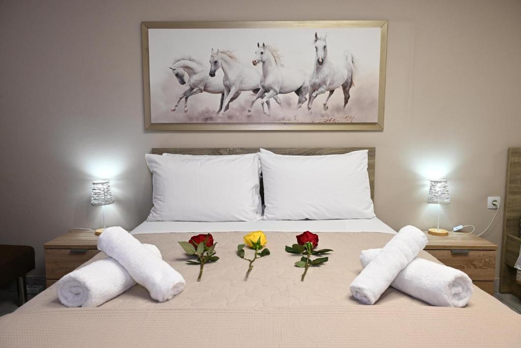 ein Bett mit Blumen und Handtüchern darauf in der Unterkunft Hotel Vasilis Nafplio in Nafplio