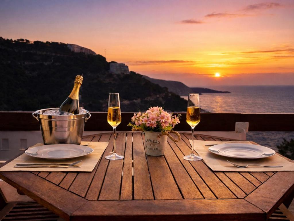 a table with a bottle of wine and two glasses at Luxury Duplex - 2 Terraces - Private Beach in Tossa de Mar