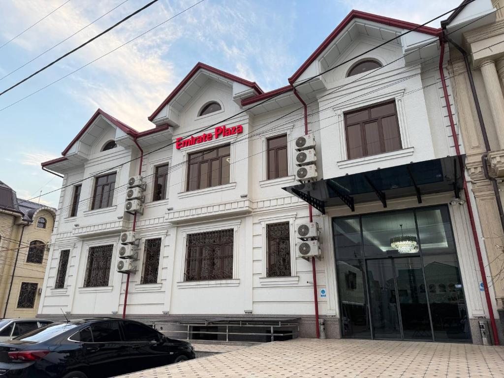 a white building with a sign on the front of it at Emirate Plaza in Sergeli