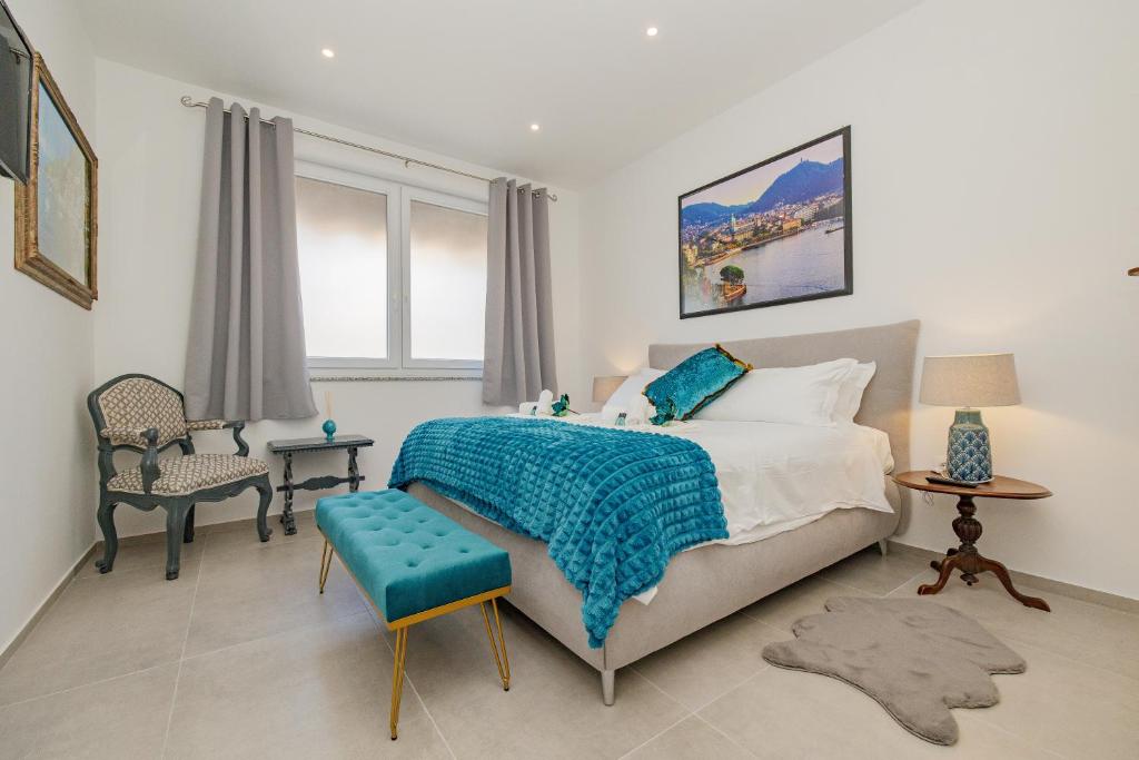 a bedroom with a bed with a blue blanket and a chair at La casa di Gaia in Como