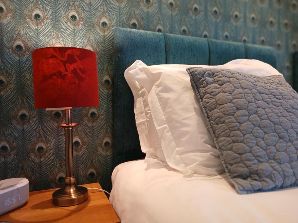 a bed with a pillow and a lamp on a table at The Briarfields in Torquay