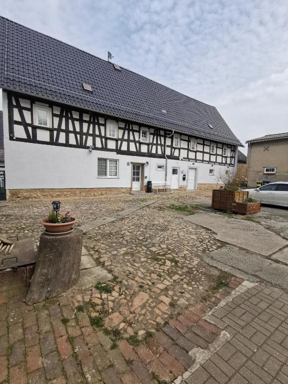 a large white building with a black roof at Gästewohnung Schönfeld in Frohburg