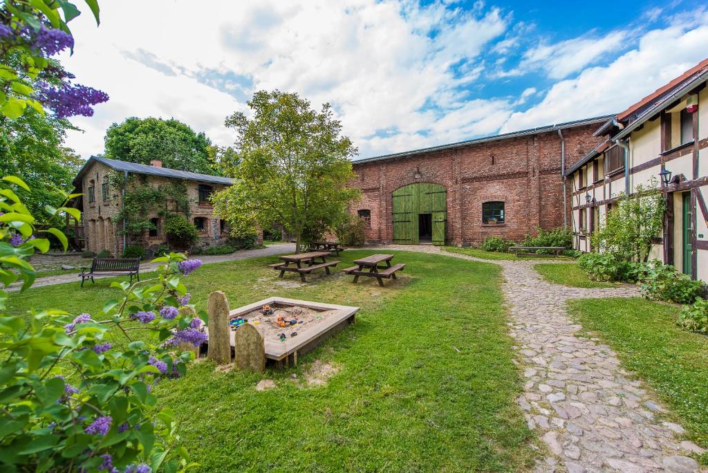 ein Garten mit einer Tischtennisplatte und Bänken in der Unterkunft Behringhof in Leuenberg