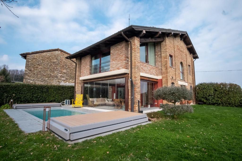 a brick house with a pool in front of it at GuestHost - Casa delle Querce Villa with Pool in Gropparello