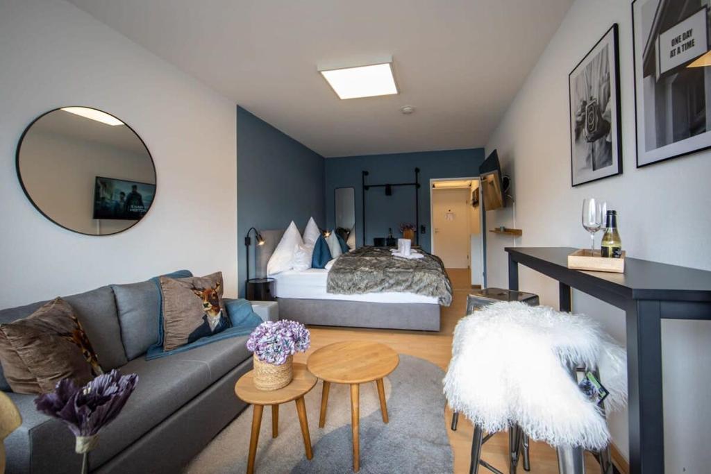 a living room with a couch and a bed at Boutique-Apartment Südblick direkt im Zentrum in Oberstdorf