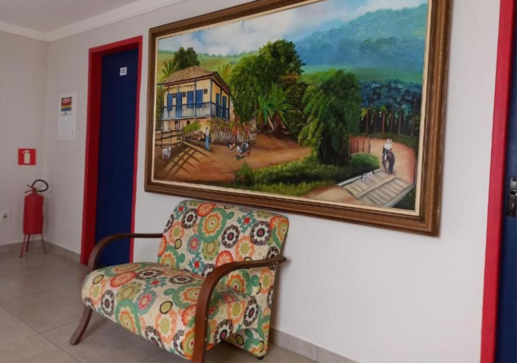 a painting hanging on a wall next to a couch at Pousada Vila Catarina in Ouro Preto