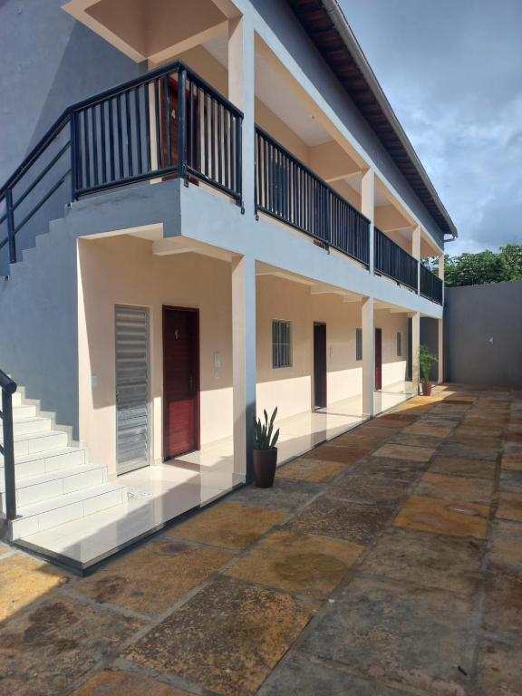 a house with a balcony and a courtyard at Apartamentos da Lua in Barreirinhas