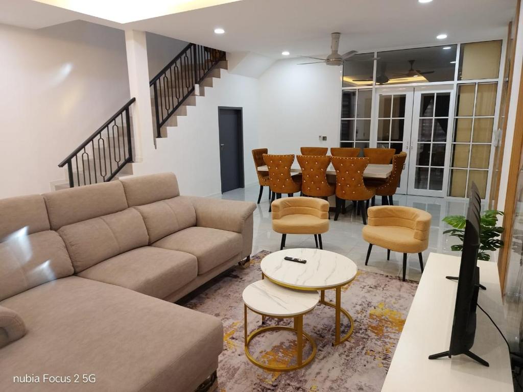 a living room with a couch and a table and chairs at HOMESTAY IMPIAN AYER MOLEK MUSLYM only in Malacca