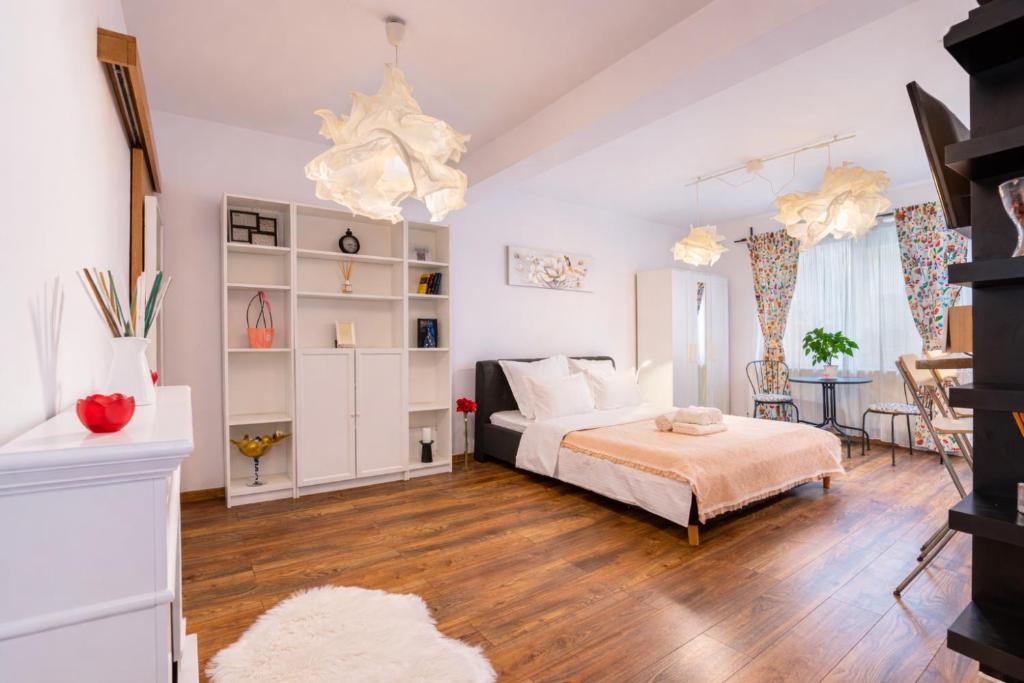 a bedroom with a bed and a living room at Alessia Homes Coressi in Braşov