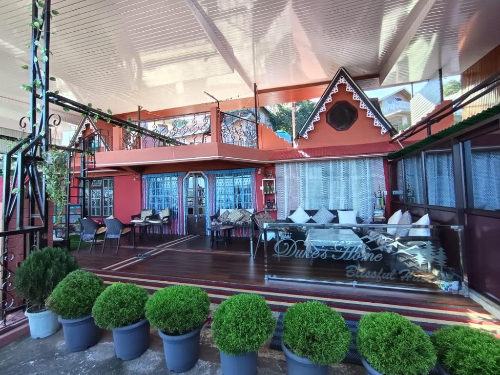 a lobby of a building with plants and chairs at Duke's RestHome in Kalimpong