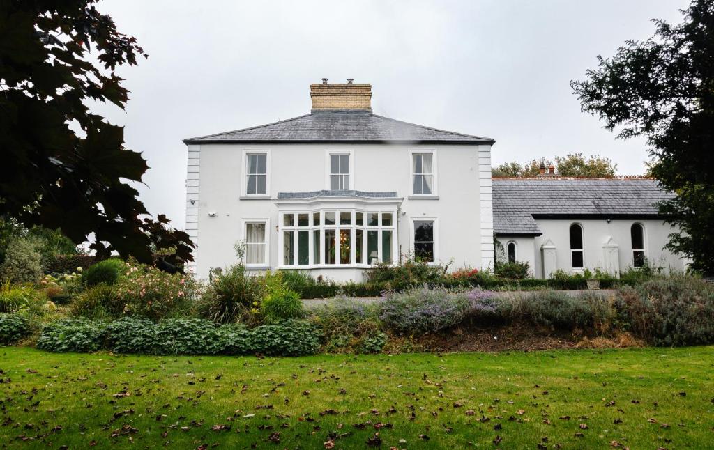 a white house with a garden in front of it at College Hill House in Slane