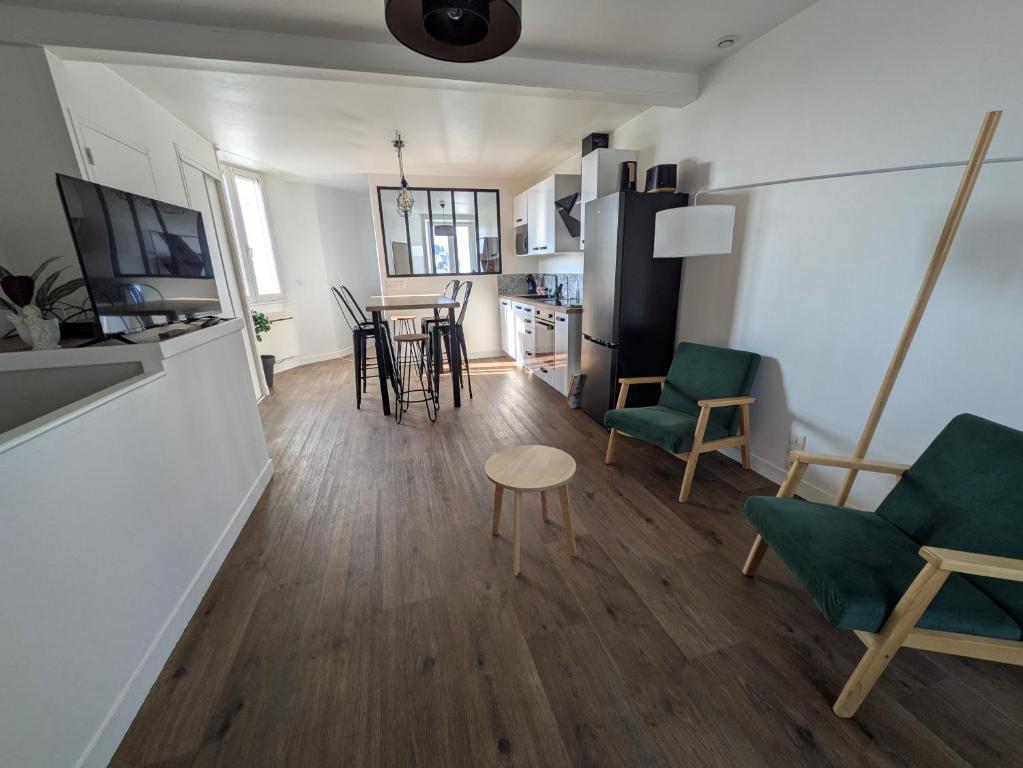 a living room and kitchen with chairs and a table at ANGEL Cozy duplex 2 chambres in Vitré
