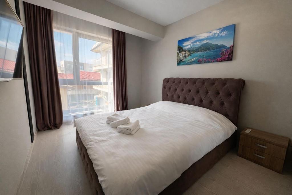 a bedroom with a bed with two towels on it at Veloria Aparthotel 1 SELF CHECK-IN #Otopeni #Airport #Therme #Bucharest in Otopeni
