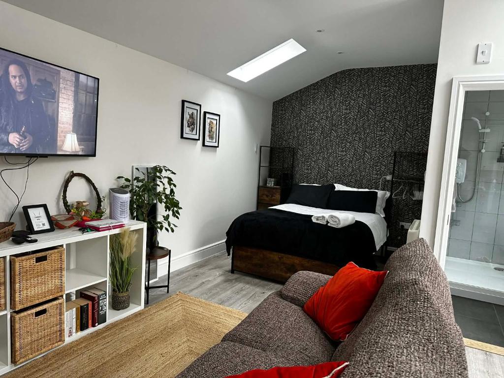 a living room with a bed and a couch at Brain Properties Limited - Garden flat with Parking near QA Hospital in Portsmouth