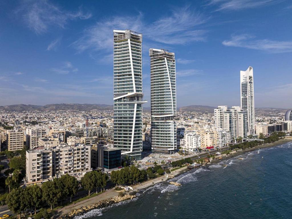 a view of a city with tall buildings and the ocean at Trilogy Limassol East Tower Seafront Apartment in Limassol