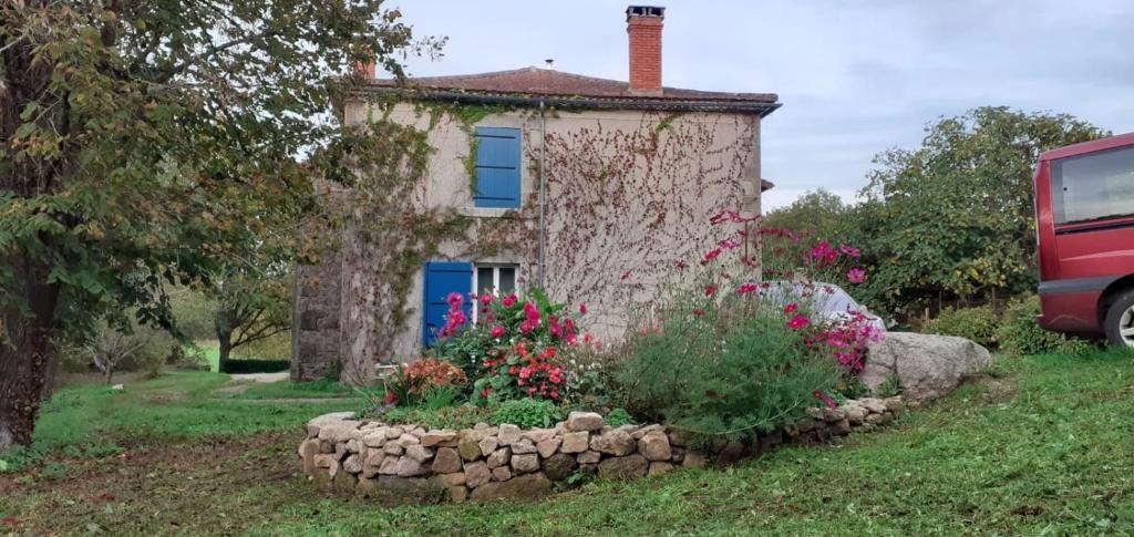 a small stone house with flowers in front of it at Lacour in Augignac