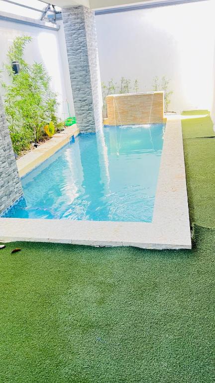 a swimming pool with a fountain in a house at D Gomez House in Santiago de los Caballeros