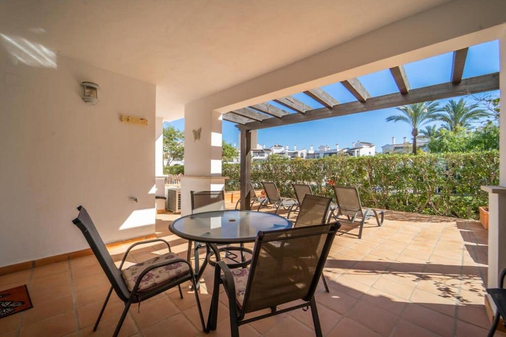 a patio with chairs and a glass table on a patio at Nice Groundfloor Apartment - BO202LT in Torre-Pacheco