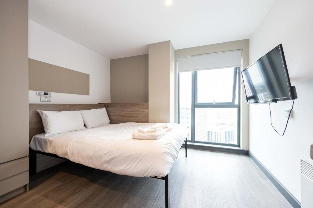 a bedroom with a bed and a flat screen tv at Studios For 2 Near Coventry Station in Coventry