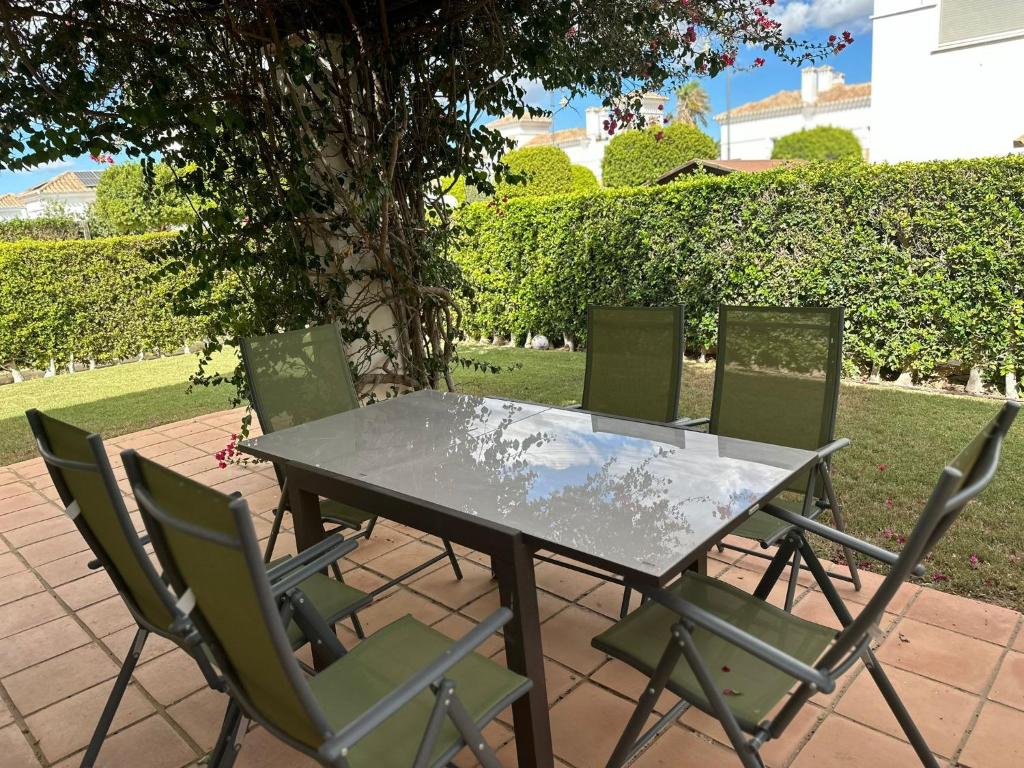 a table with four chairs and a table and a tree at Spacious Villa - DN32LT in Torre-Pacheco