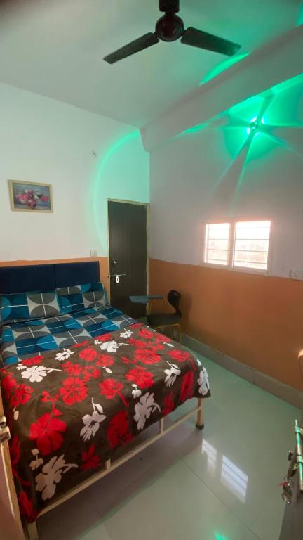 a bedroom with a bed and a ceiling fan at Green male rooms in Bhopal