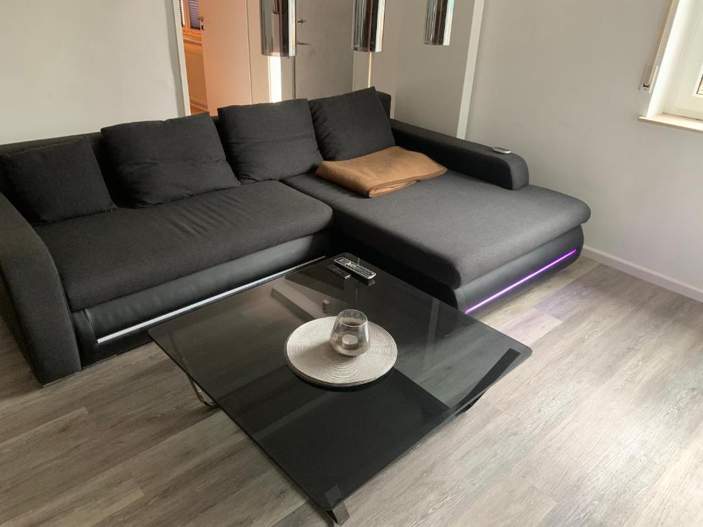 a living room with a black couch and a table at Appartement in Bad Kreuznach