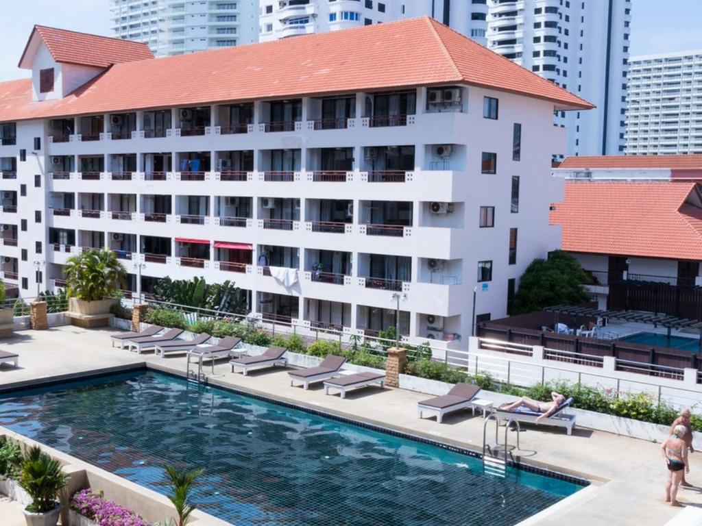 un hotel con piscina frente a un edificio en Jomtien Plaza Residence, en Jomtien Beach